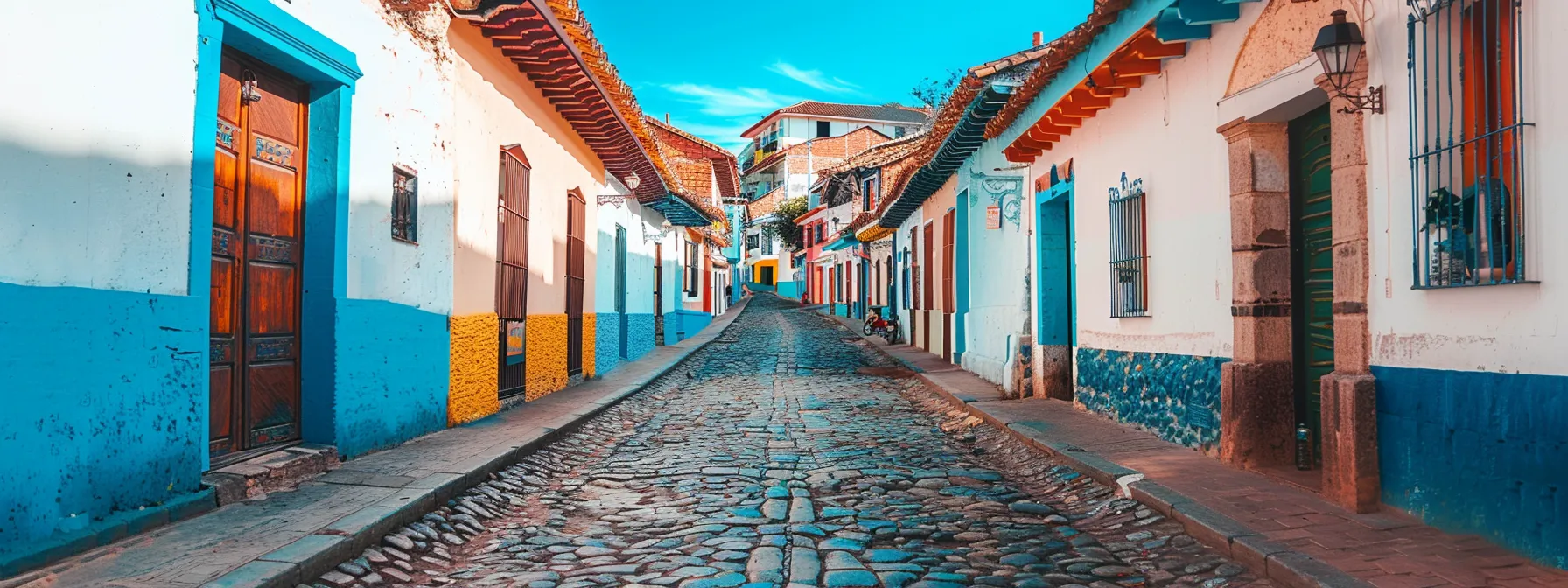 a cobblestone street lined with colorful colonial buildings, showcasing the historic charm of sucre in bolivia.